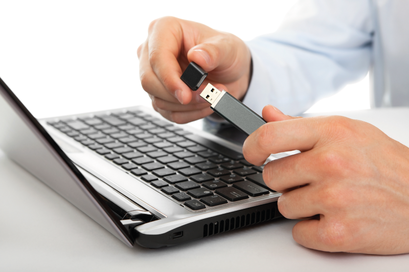 Holding USB Flash Drive near Laptop