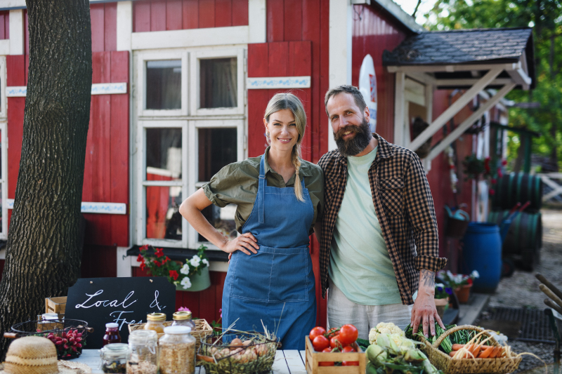 Couple selling produce in front of farm store