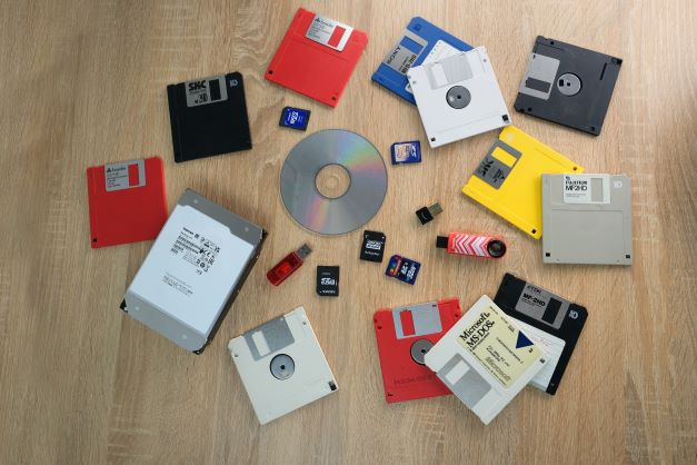 assorted storage devices - USB drives, memory cards, floppy discs, and CDs