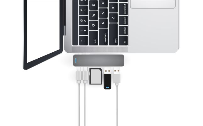 Mac laptop sideways with various Flash Drive types and wires plugged into Ports